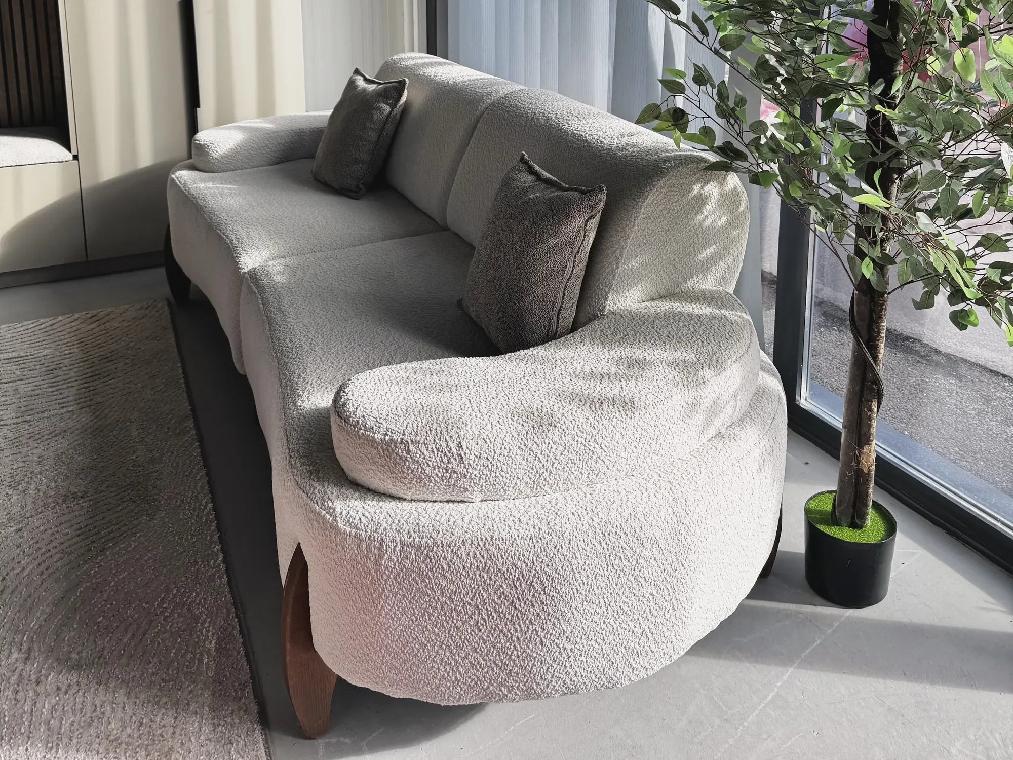 Garniturë e bardhë e lakuar me jastëkë gri në showroom